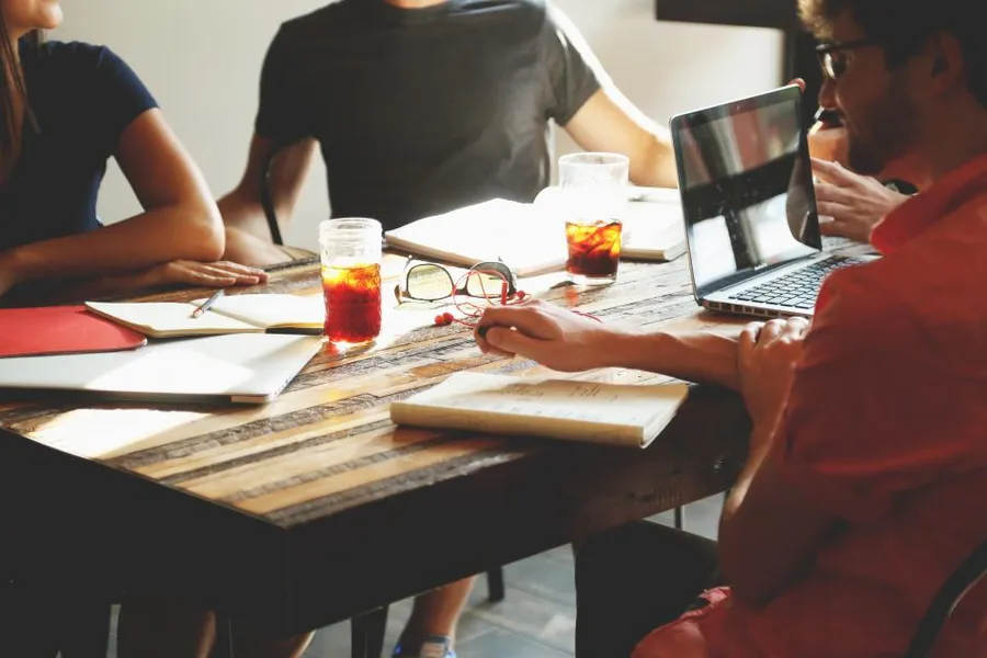 A team working through documents together at a meeting table.